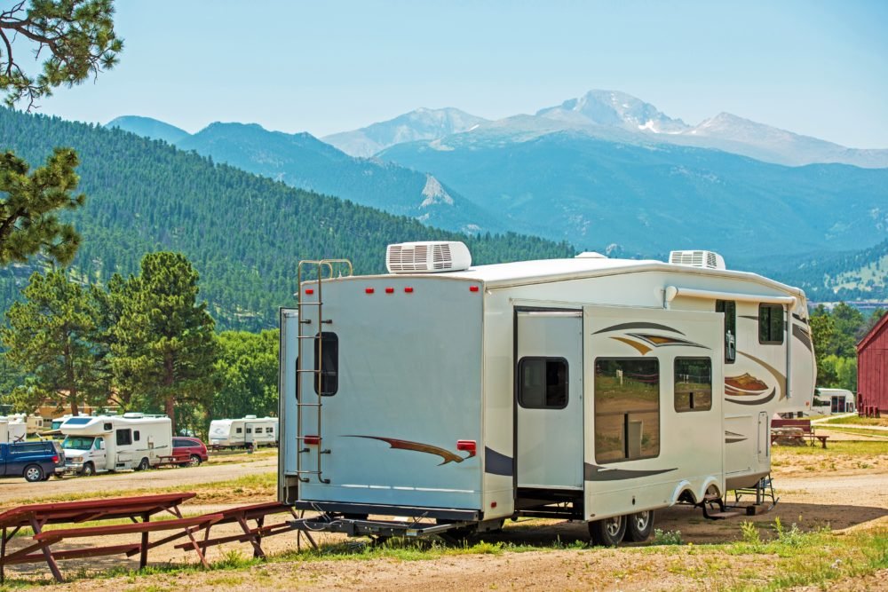 5th wheel RV in campground with mountain background