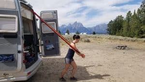 Woman uses elastic bands to workout by RV van