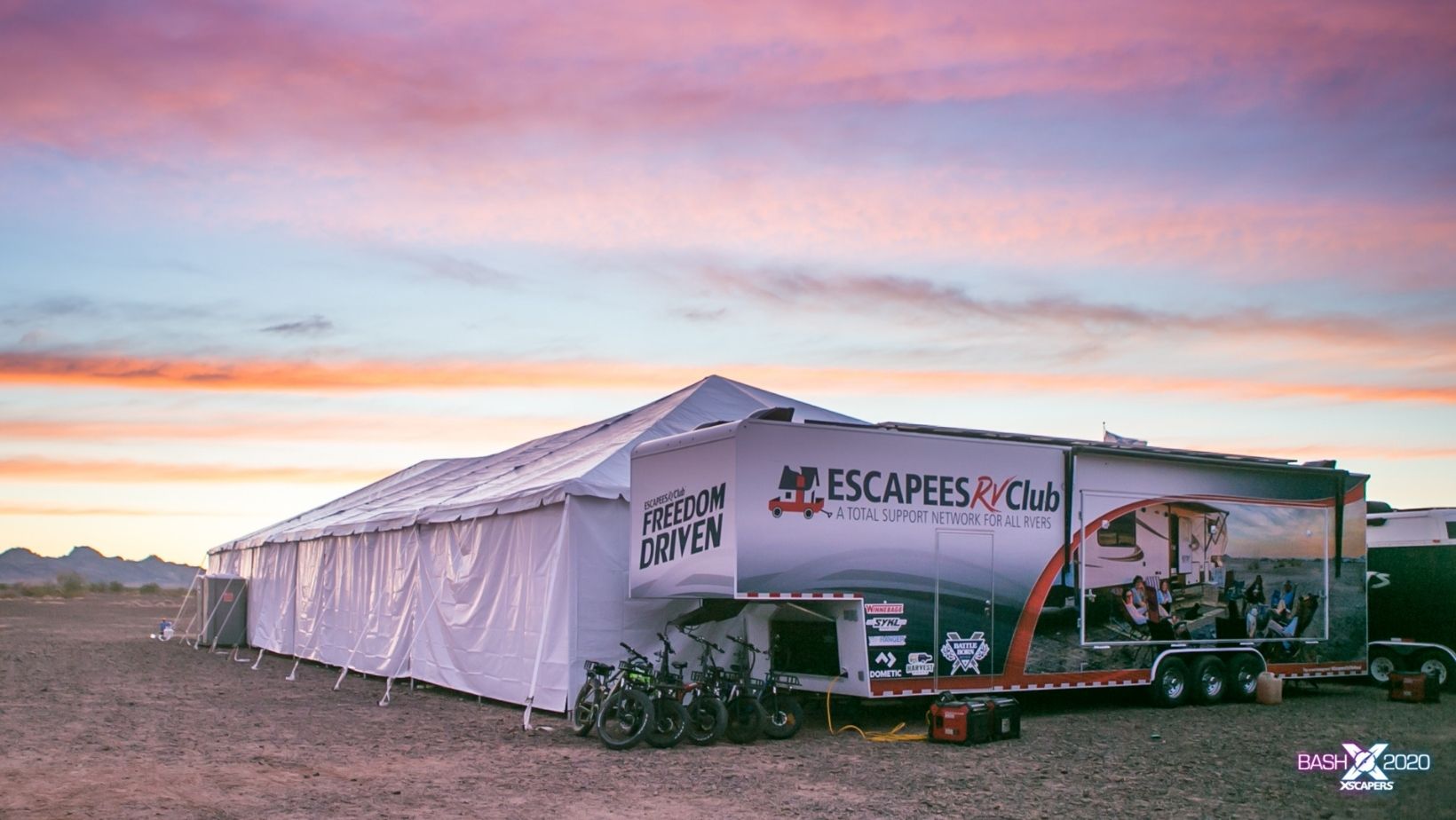 View of the entire Escapees event trailer with tent deployed and e-bikes parked nearby.