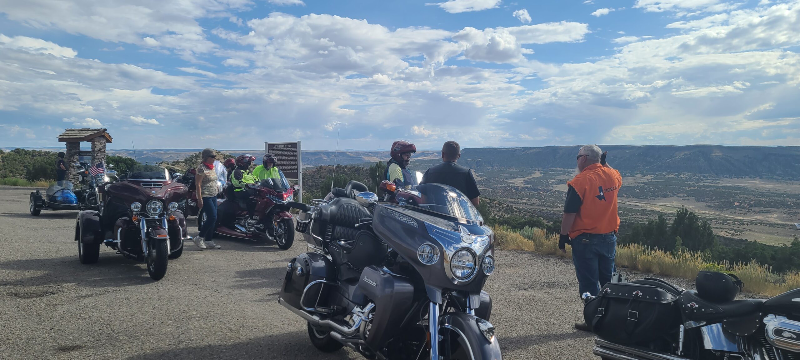 Motorcyclists overlooking a valley from a rest area