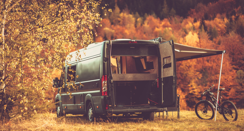Camper van boondocking in forest during Autumn