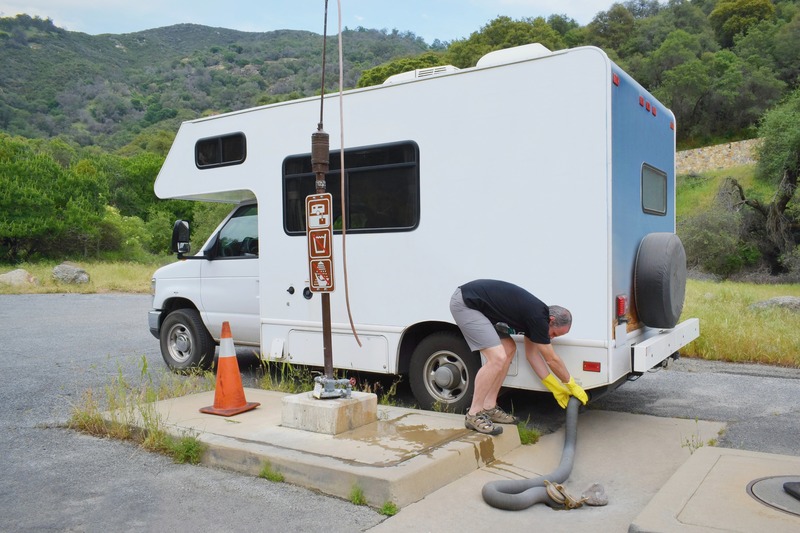 Man dumping waste water from RV at dump station